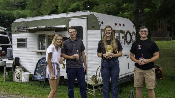 a group of people standing in front of a trailer